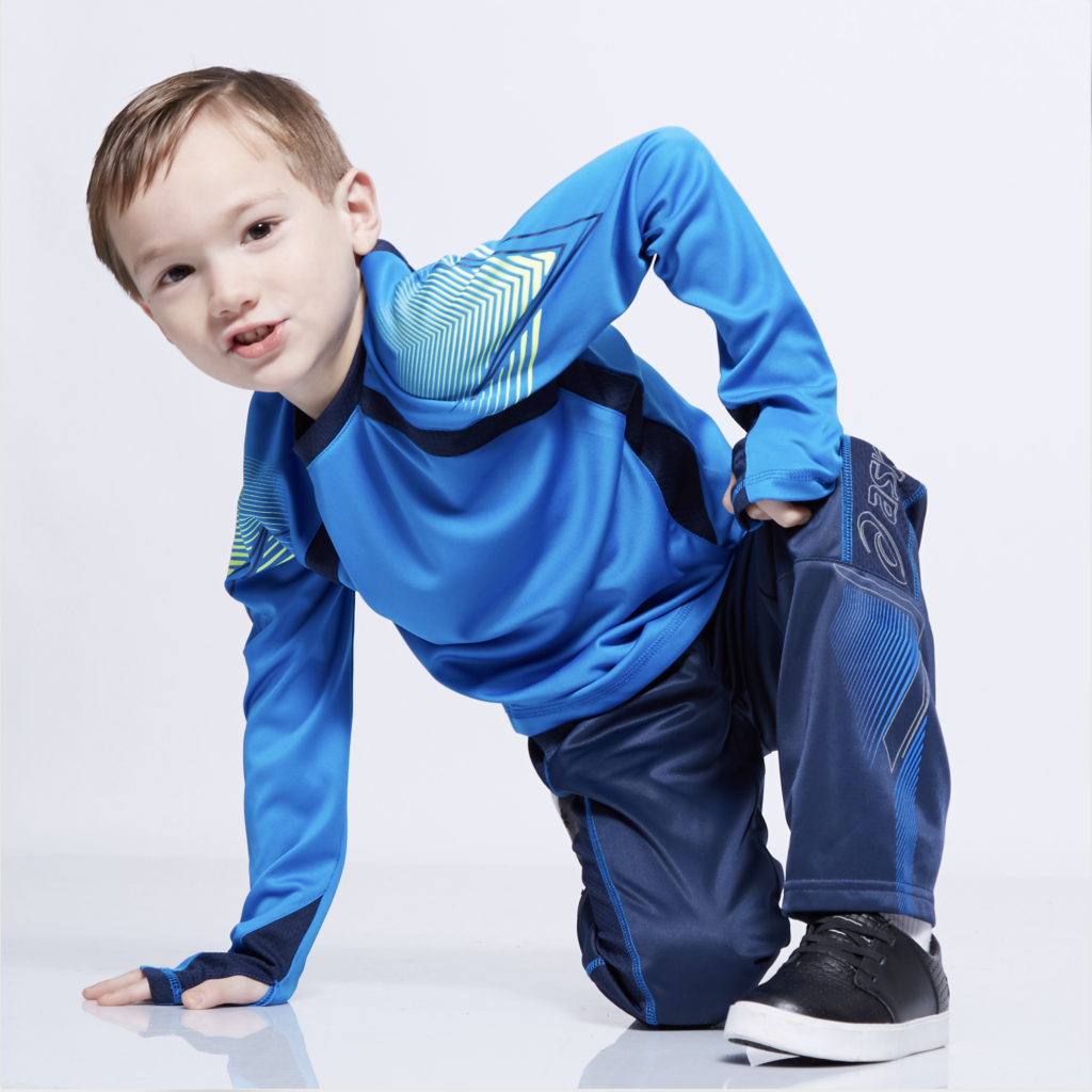Bryan Carle THOB Original Editorial Kids Boy Clothing Active Wear Asics Top Blue Fluorescent Green Graphic Long Sleeve Bottoms Navy Blue Asics Black Shoes Modern White Background Cool Kid Street Style